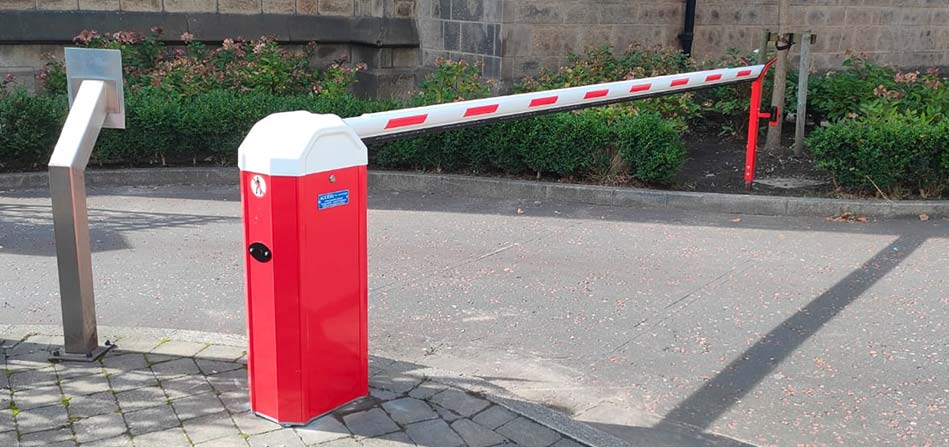 A red vehicle barrier with a white top. The bar is red and white striped.